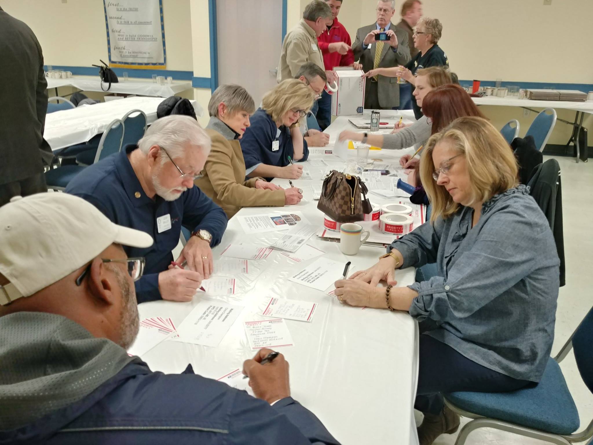 Adopt-A-Platoon Clayton Rotarians filling out the customs forms for our boxes